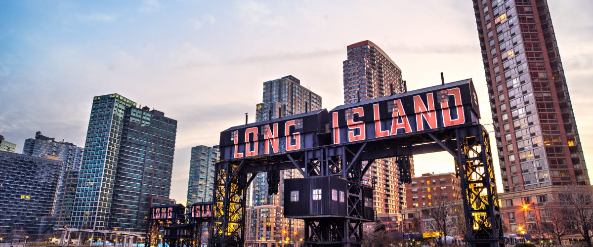 Large painted lettering spelling out Long Island in front of some taller buildings