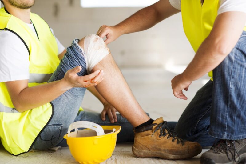 Injured construction worker with knee taped up.