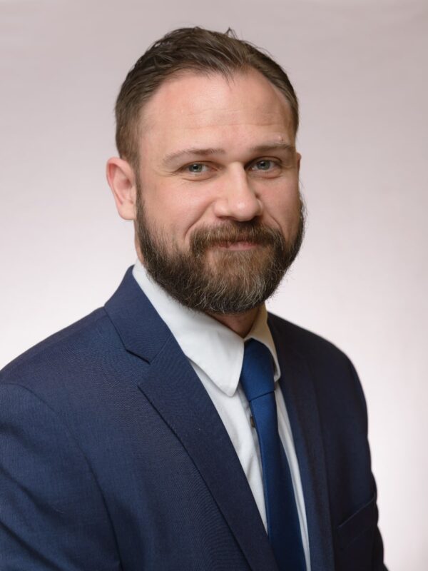 headshot of partner attorney Zachary Beriloff, a handsome 40-something white man with a trimmed beard wearing a navy blue suit